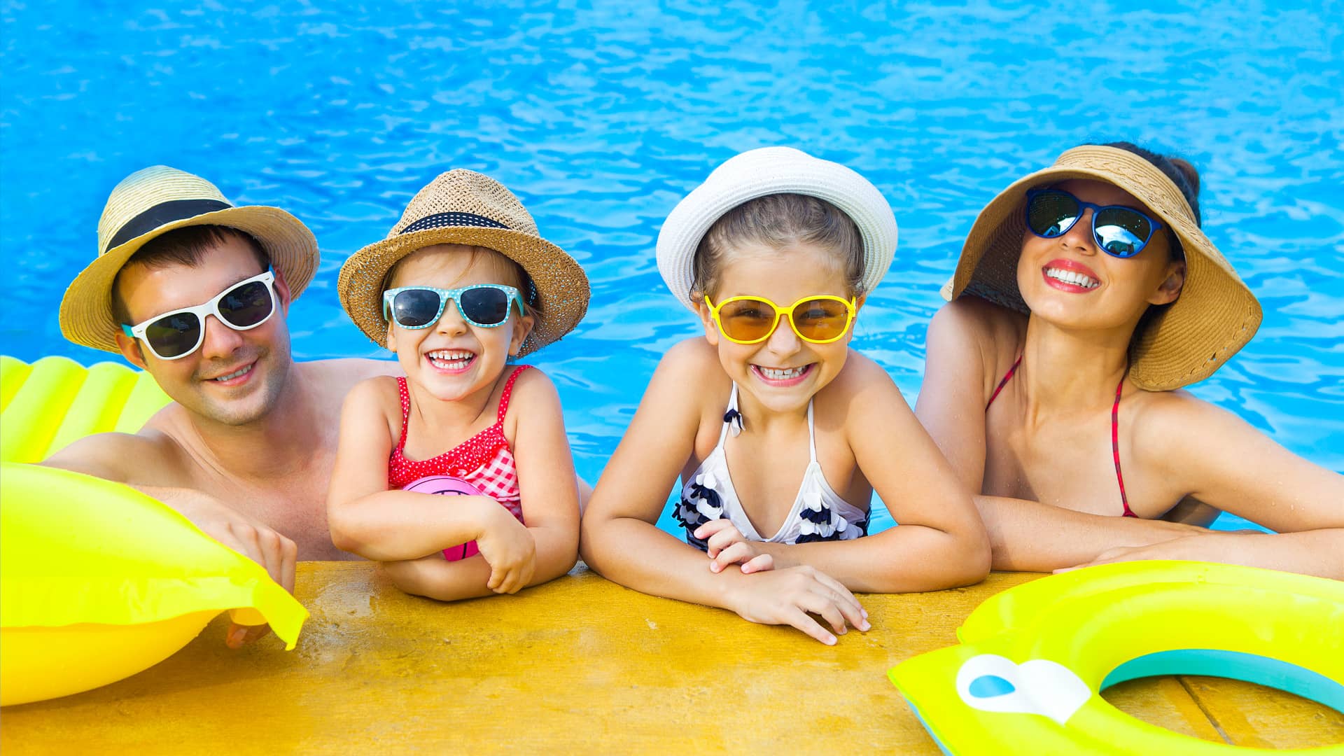 Famiglia sorridente in piscina in vacanza